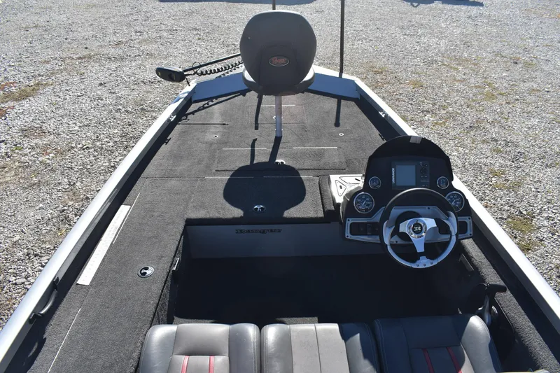 Slide: The Image of 2015 Ranger RT178C boat interior with steering wheel and seating on gravel surface. - 8