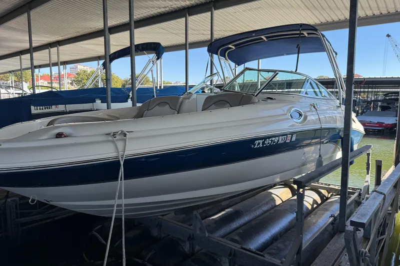 Slide: The Image of 2004 Sea Ray 270 Sundeck boat docked in a marina under a covered shelter. - 2