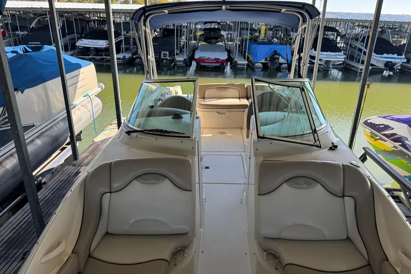 Slide: The Image of 2004 Sea Ray 270 Sundeck boat interior at marina, featuring spacious seating and windshield. - 4