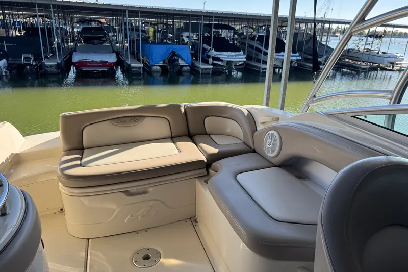 Slide: The Image of 2004 Sea Ray 270 Sundeck interior with beige seating, docked at marina. - 6