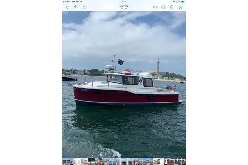 The Image of 2022 Ranger Tugs R-25 boat on water, red hull, scenic background. - 0