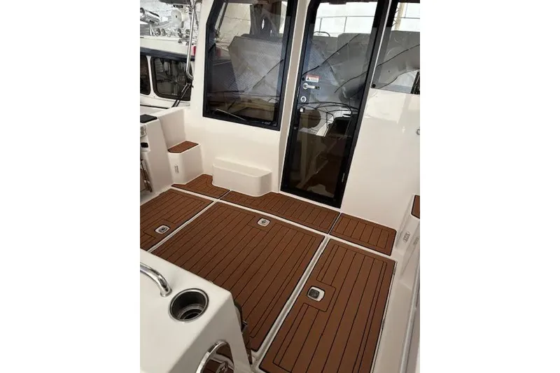 Slide: The Image of 2022 Ranger Tugs R-25 boat interior with teak flooring and glass door. - 14