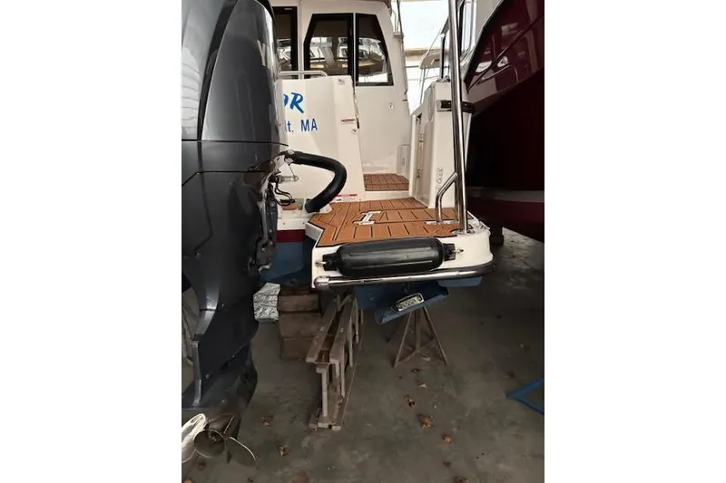 Slide: The Image of 2022 Ranger Tugs R-25 boat with outboard motor, docked indoors. - 17