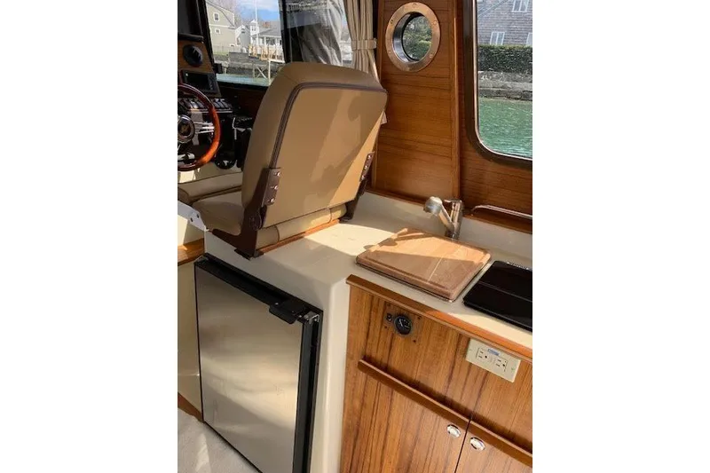 Slide: The Image of Interior of 2022 Ranger Tugs R-25 boat with wooden cabinetry and seating. - 19