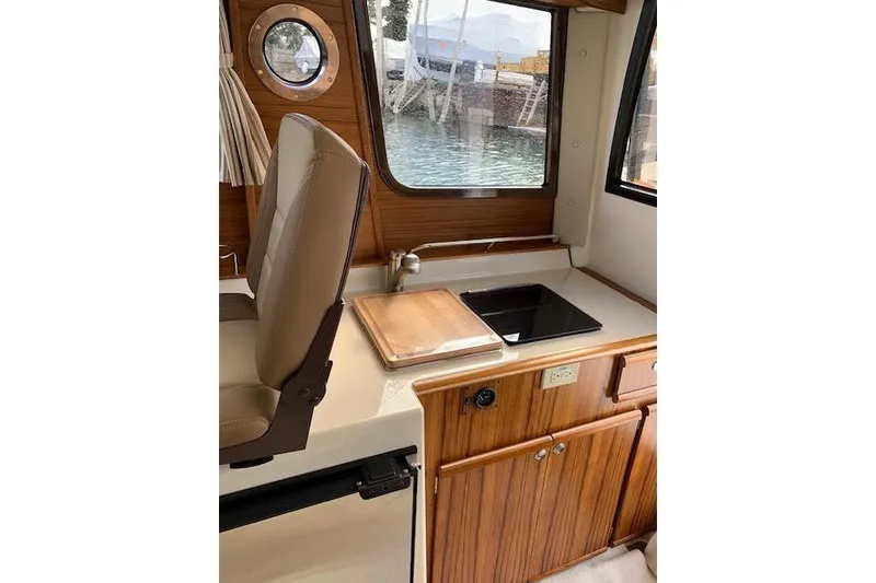 Slide: The Image of Interior of 2022 Ranger Tugs R-25 boat with kitchenette and window view. - 20