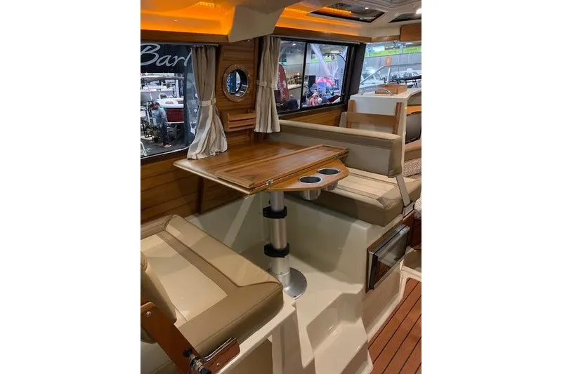Slide: The Image of Interior of 2022 Ranger Tugs R-25, featuring a cozy dining area with wood accents. - 23