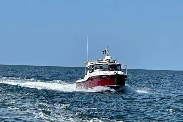 Slide: The Image of 2022 Ranger Tugs R-25 cruising on open water under clear blue skies. - 8