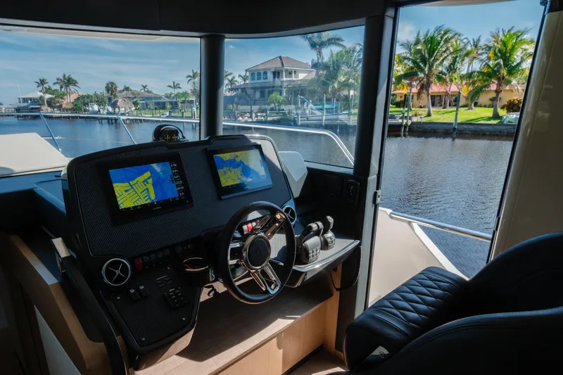 Slide: The Image of Cockpit view of 2020 Absolute 48 Navetta yacht with waterfront scenery. - 24