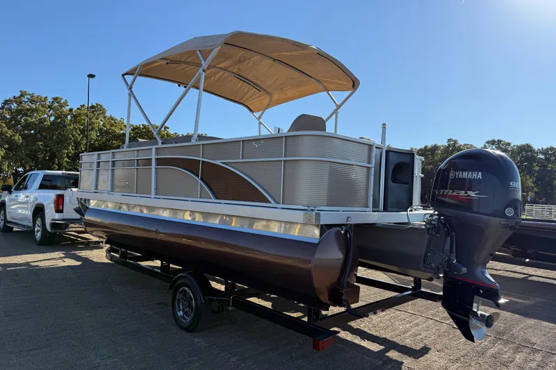 Slide: The Image of 2020 Bennington 21SF pontoon boat with canopy on trailer by the water. - 106