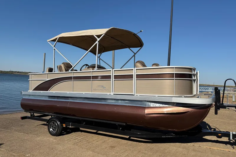 Slide: The Image of 2020 Bennington 21SF pontoon boat with canopy on trailer, parked outdoors. - 109