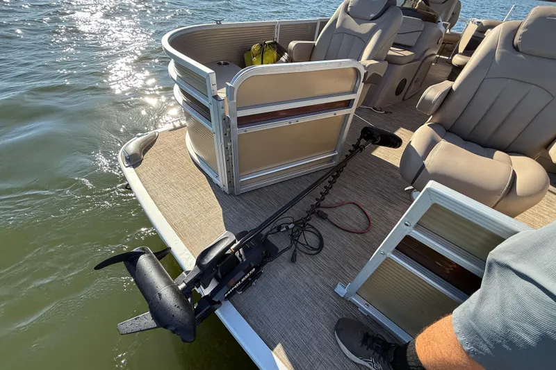 Slide: The Image of 2020 Bennington 21SF pontoon boat with motor, beige seats, and open water view. - 114