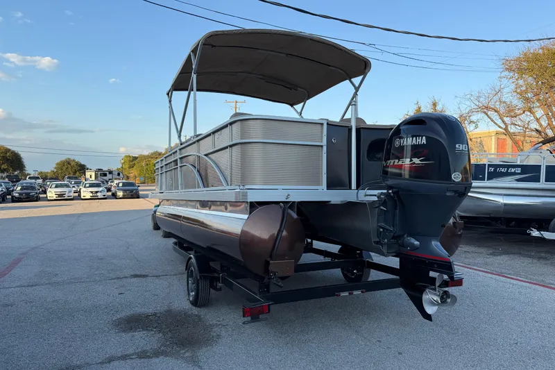 Slide: The Image of Close-up of a 2020 Bennington 21SF boat's metallic brown exterior reflecting the sunset. - 16