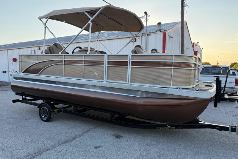 Slide: The Image of 2020 Bennington 21SF pontoon boat with Yamaha engine, parked on a trailer. - 22