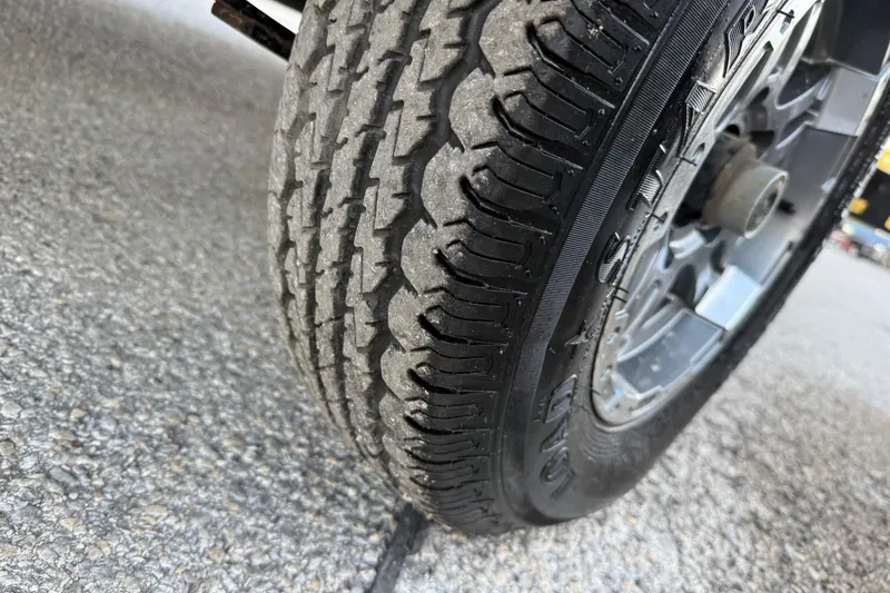 Slide: The Image of Close-up of a 2020 Bennington 21SF trailer wheel with black fender and orange reflector. - 69