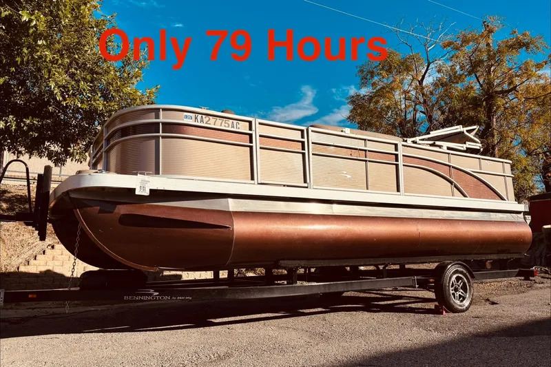 Slide: The Image of 2020 Bennington 21SF pontoon boat on trailer, parked outdoors under clear sky. - 7