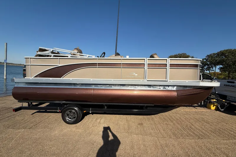 Slide: The Image of 2020 Bennington 21SF pontoon boat on trailer by the water. - 74