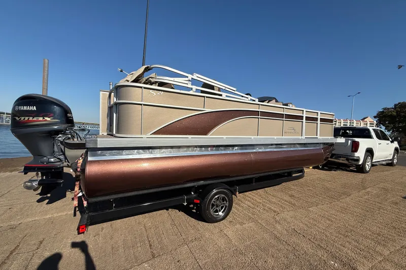 Slide: The Image of 2020 Bennington 21SF pontoon boat on trailer by a lake under clear blue sky. - 76