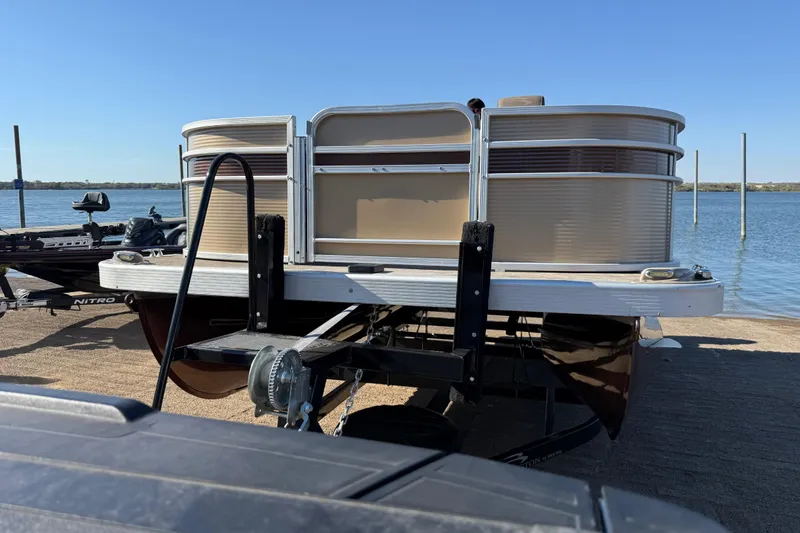 Slide: The Image of 2020 Bennington 21SF pontoon boat on trailer by a lake. - 85