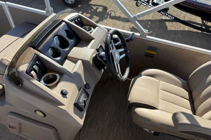 Slide: The Image of 2020 Bennington 21SF boat interior with beige seating, docked by a lake. - 97