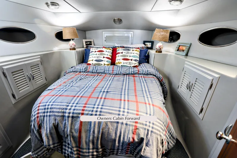 Slide: The Image of Owner's cabin in 1993 Mediterranean 38 Convertible yacht, featuring cozy bed and nautical decor. - 14