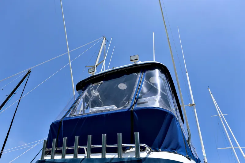 Slide: The Image of 1993 Mediterranean 38 Convertible boat with blue canopy against clear sky. - 23