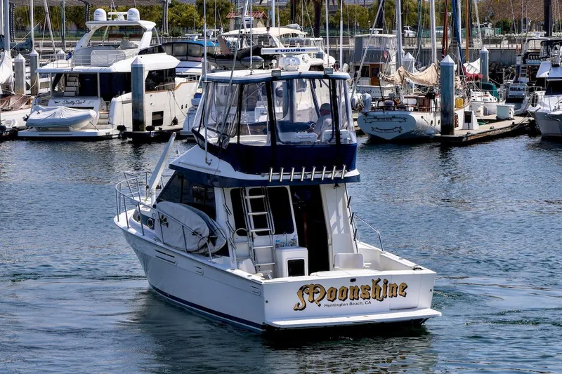Slide: The Image of 1993 Mediterranean 38 Convertible yacht named "Moonshine" in a marina setting. - 3