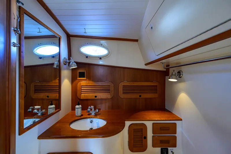 Slide: The Image of Luxurious 2017 Hinckley Picnic Boat 37 MKIII bathroom with wooden cabinetry and elegant fixtures. - 29