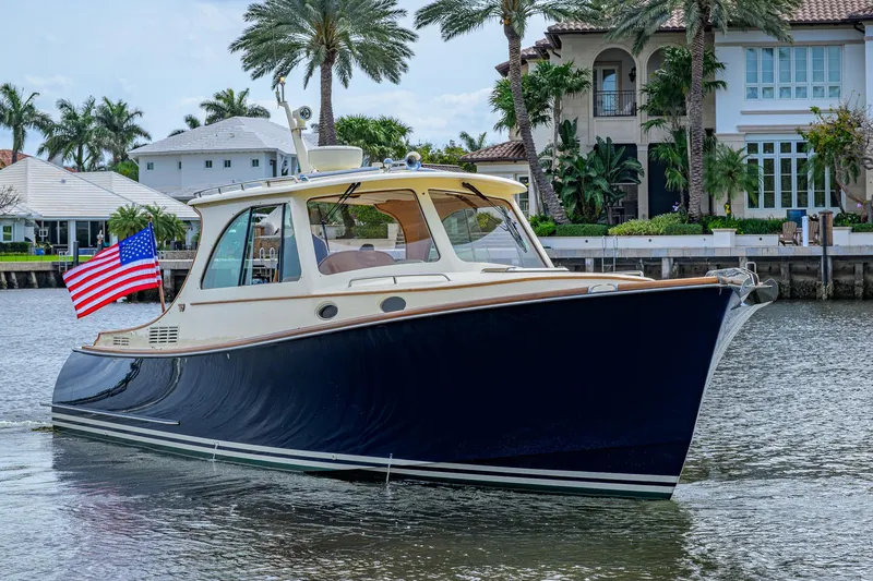 Slide: The Image of 2017 Hinckley Picnic Boat 37 MKIII cruising near waterfront homes with American flag. - 7