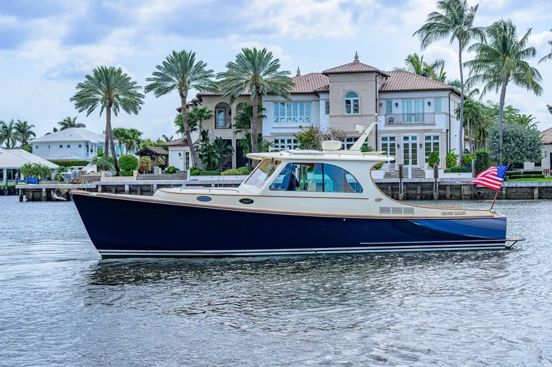 Slide: The Image of 2017 Hinckley Picnic Boat 37 MKIII cruising near luxury waterfront homes. - 10