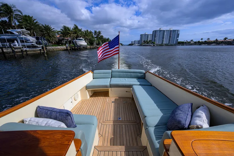Slide: The Image of 2017 Hinckley Picnic Boat 37 MKIII cruising with American flag, luxurious seating, waterfront view. - 14