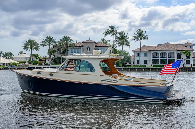 Slide: The Image of 2017 Hinckley Picnic Boat 37 MKIII cruising near waterfront homes with palm trees. - 2