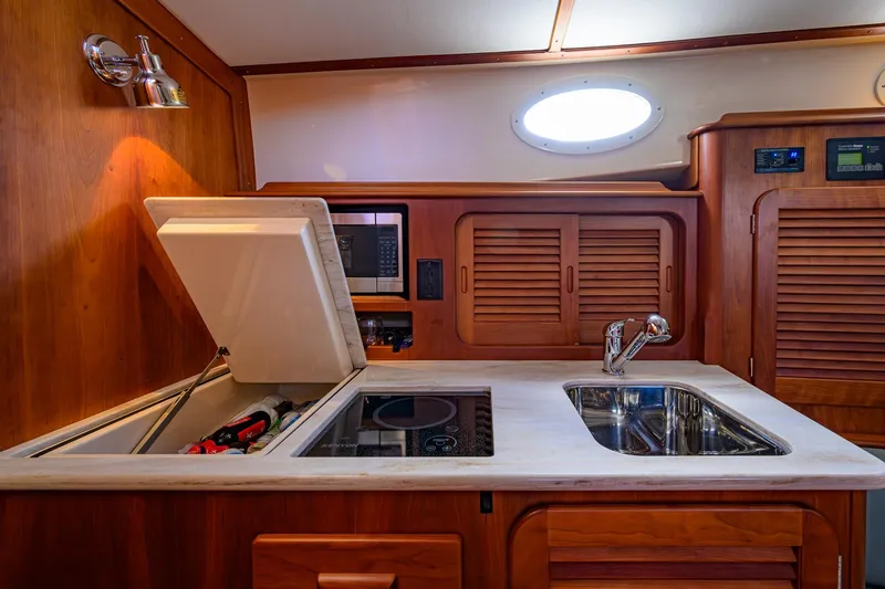 Slide: The Image of 2017 Hinckley Picnic Boat 37 MKIII interior kitchen with sink and storage. - 27