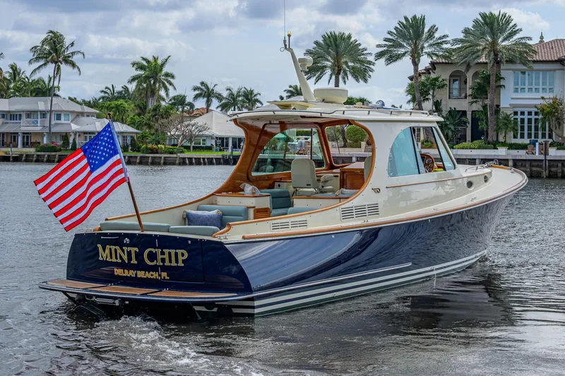 Slide: The Image of 2017 Hinckley Picnic Boat 37 MKIII cruising with American flag, palm trees in background. - 5