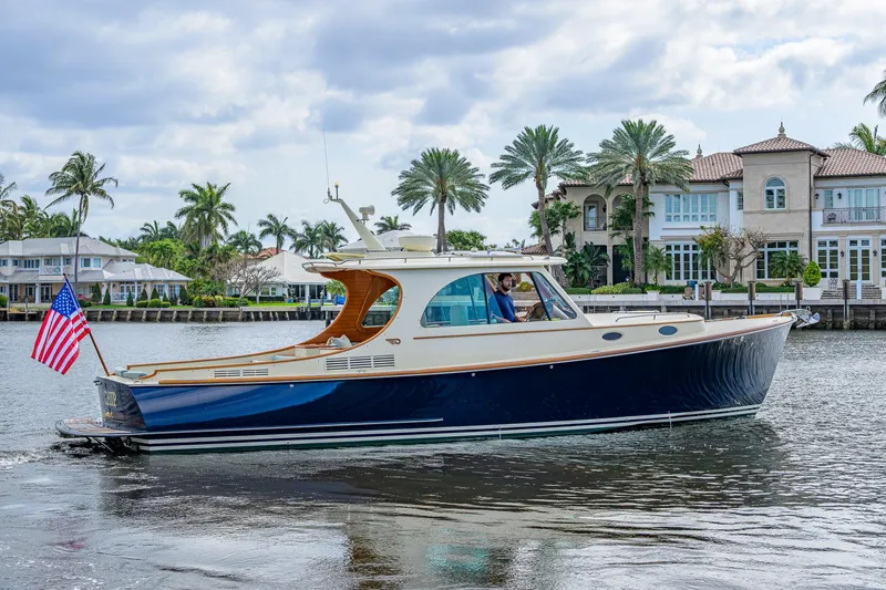Slide: The Image of 2017 Hinckley Picnic Boat 37 MKIII cruising near waterfront homes with palm trees. - 6