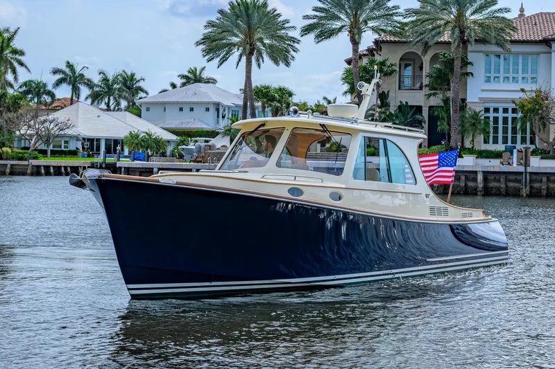 Slide: The Image of 2017 Hinckley Picnic Boat 37 MKIII cruising near waterfront homes with palm trees. - 9