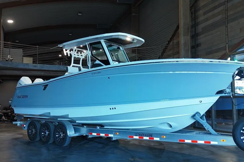The Image of 2023 Blackfin 302 CC boat on trailer in indoor showroom. - 0