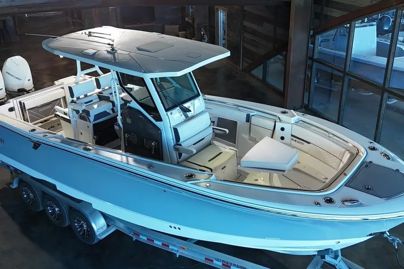 Slide: The Image of 2023 Blackfin 302 CC boat on trailer in showroom, showcasing sleek design and spacious interior. - 1