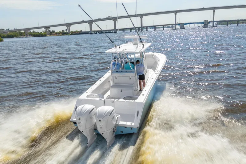 Slide: The Image of 2025 SeaHunter 31 Tournament boat cruising on a sunny day near a bridge. - 1