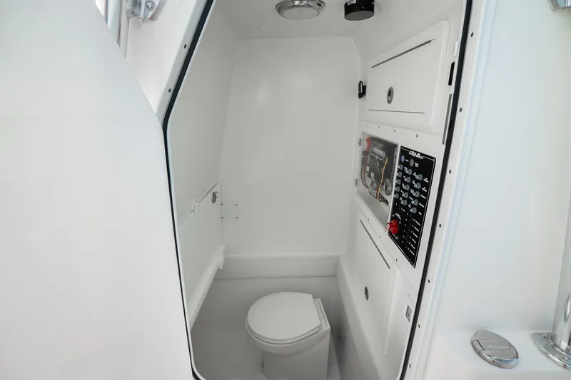 Slide: The Image of 2025 SeaHunter 31 Tournament boat interior with compact marine toilet and control panel. - 18