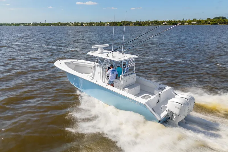 Slide: The Image of 2025 SeaHunter 31 Tournament boat cruising on open water, featuring dual outboard engines. - 4