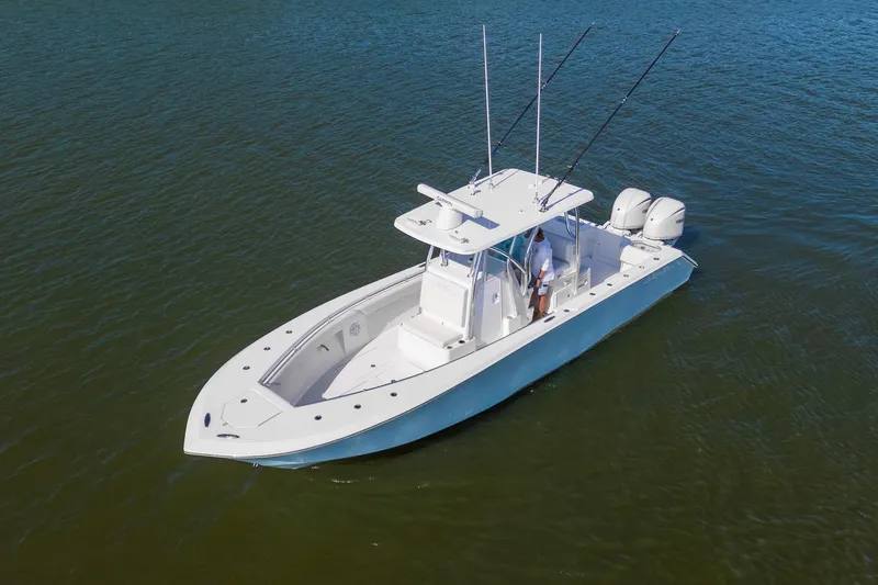 Slide: The Image of 2025 SeaHunter 31 Tournament boat on calm water, featuring dual outboard engines. - 7