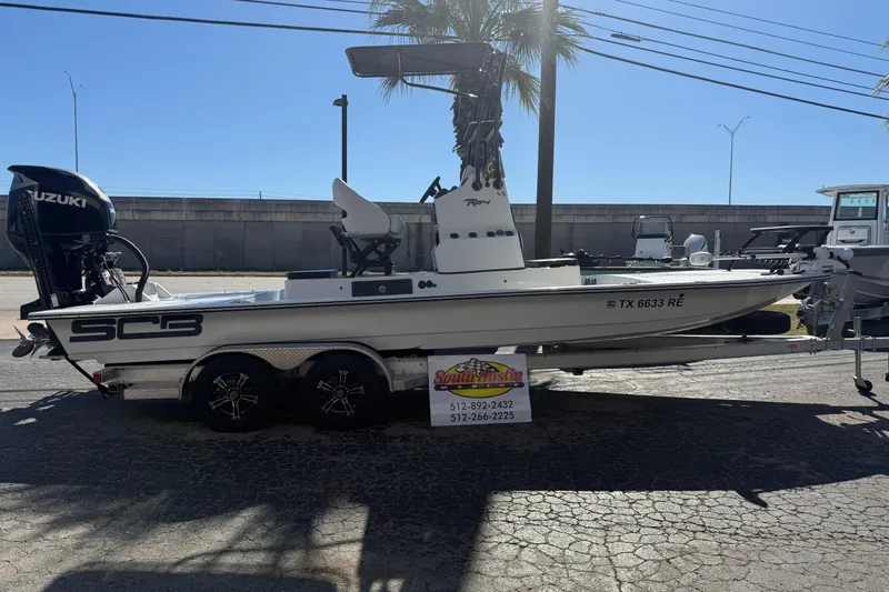 The Image of 2024 SCB R24 boat with Suzuki engine on calm water under clear blue sky. - 0