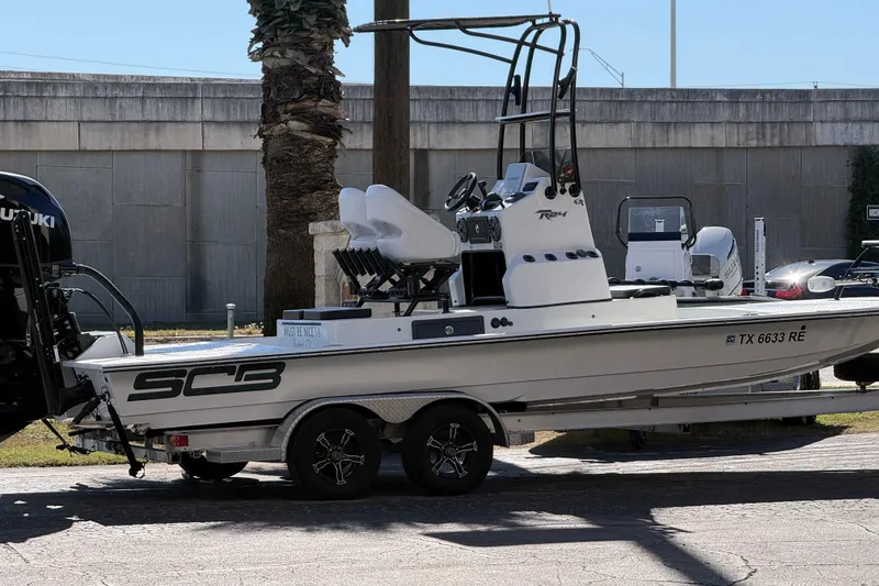 Slide: The Image of 2024 SCB R24 boat with open storage compartment and trolling motor on deck. - 46