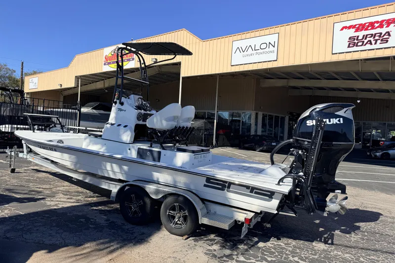 Slide: The Image of 2024 SCB R24 boat with Suzuki engine on trailer outside dealership. - 56