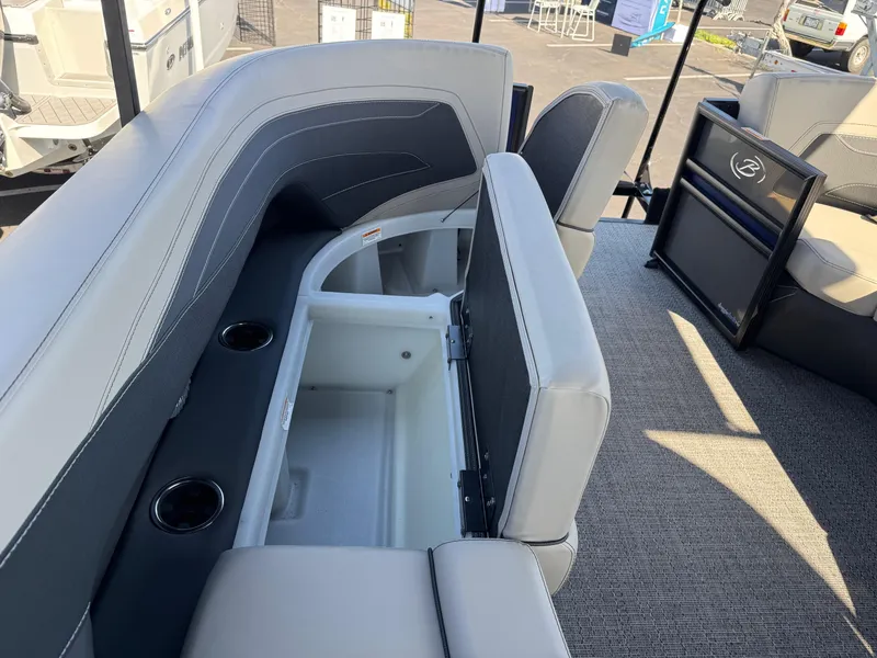 Slide: The Image of 2026 Barletta Cabrio 24U boat interior with open storage compartment and cup holders. - 16