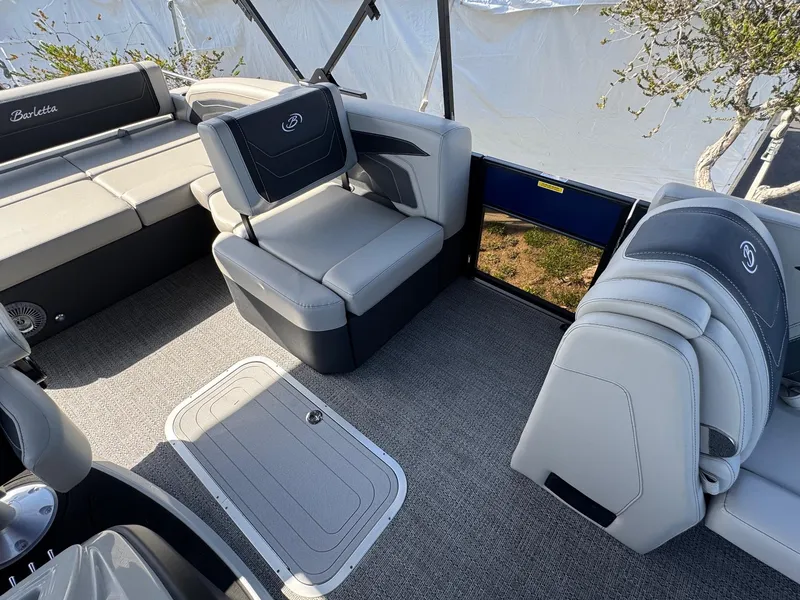 Slide: The Image of 2026 Barletta Cabrio 24U boat interior with gray seating and carpeted flooring. - 25