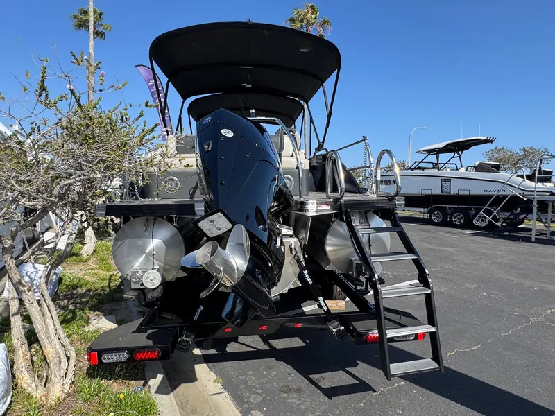 Slide: The Image of 2026 Barletta Cabrio 24U pontoon boat with outboard motor and ladder, parked outdoors. - 8