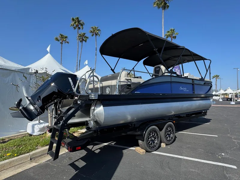 Slide: The Image of 2026 Barletta Cabrio 24U pontoon boat on trailer, parked outdoors with palm trees. - 9