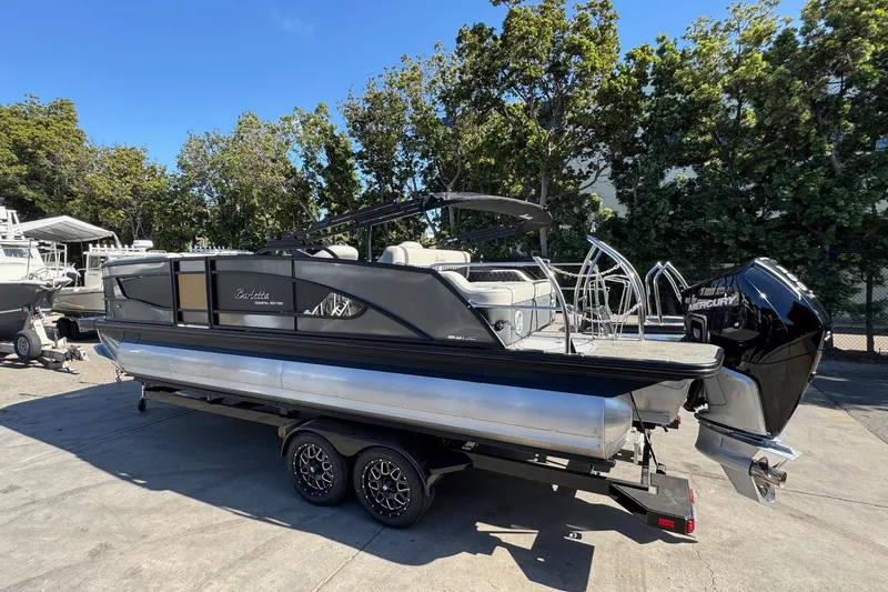 Slide: The Image of 2026 Barletta Lusso 23UC pontoon boat on trailer, parked outdoors. - 115