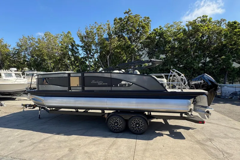 Slide: The Image of 2026 Barletta Lusso 23UC pontoon boat on trailer, parked outdoors. - 116